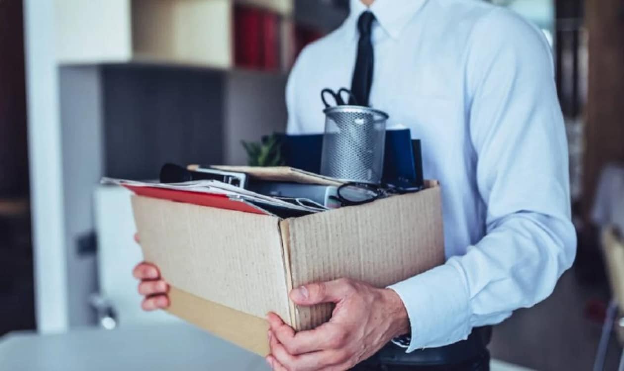 Un bărbat își cară într-o cutie lucrurile de la birou, după ce a fost concediat