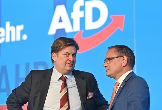 Fost asistent al unui lider AfD, condamnat la aproape cinci ani de închisoare pentru spionaj în favoarea Chinei. A colectat documente din Parlamentul European